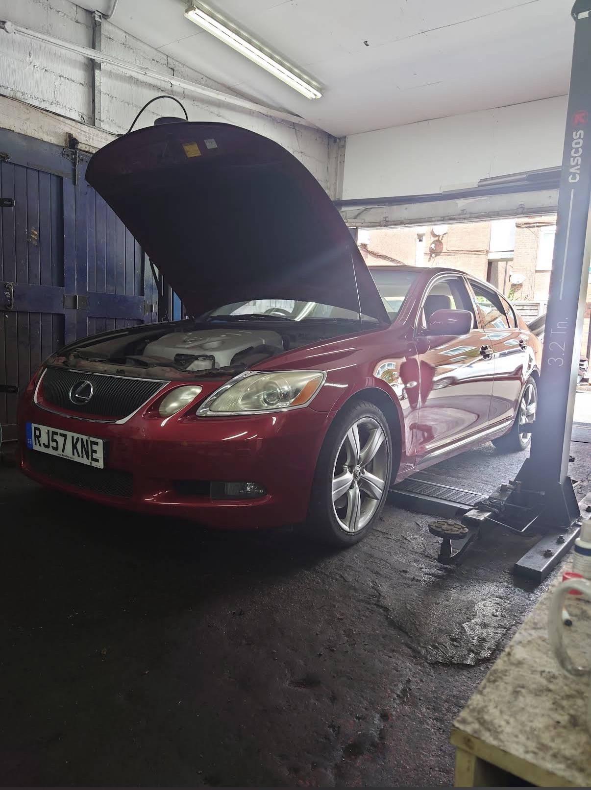 Lexus GS on hydraulic lift inside AMP workshop